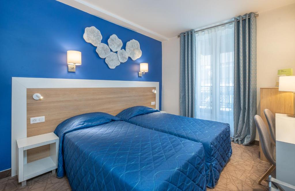 巴黎蒙帕纳斯总站酒店的蓝色的卧室设有床和窗户