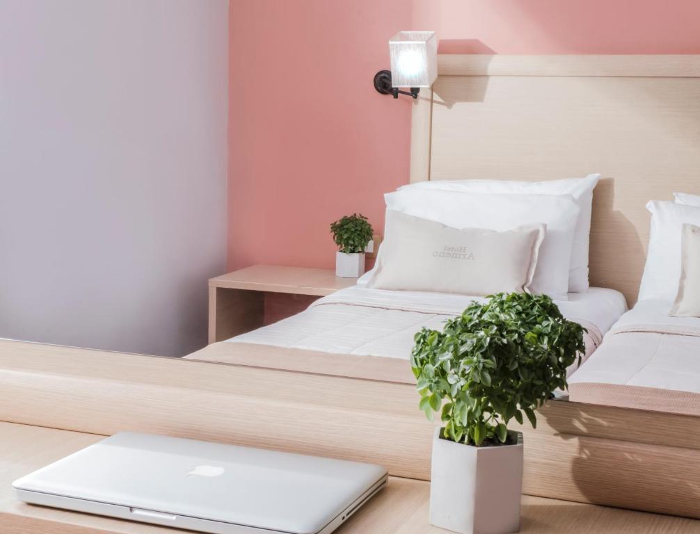 奈德里Armeno beach hotel的一间卧室配有一张床和一张桌子上的笔记本电脑