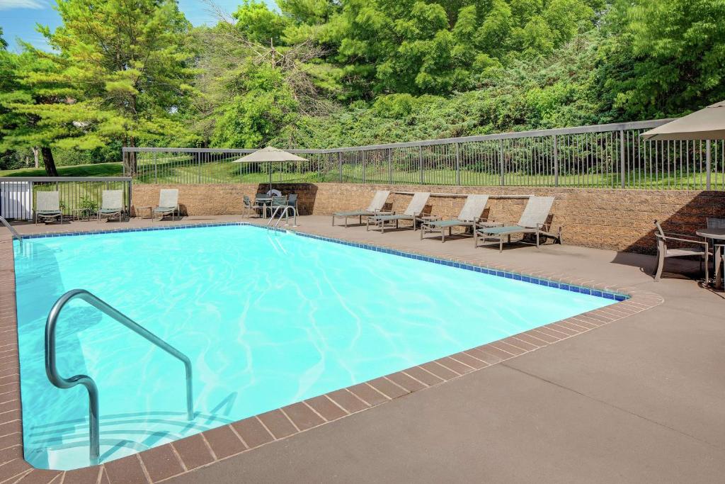 州学院州立学院希尔顿恒庭酒店的一个带椅子和桌子的大型游泳池