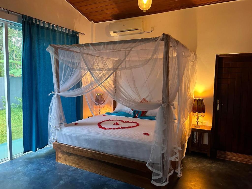 达瓦拉维Amba Kola Udawalawa的一间卧室配有一张带天蓬的床