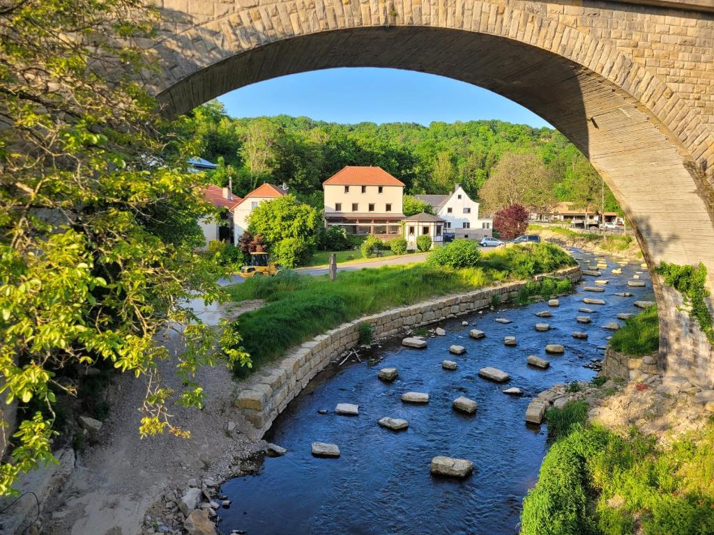 IrrelIrreler Mühle Ferienwohnungen und Ferienhäuser的河上一座桥,河中岩石堆积在水中