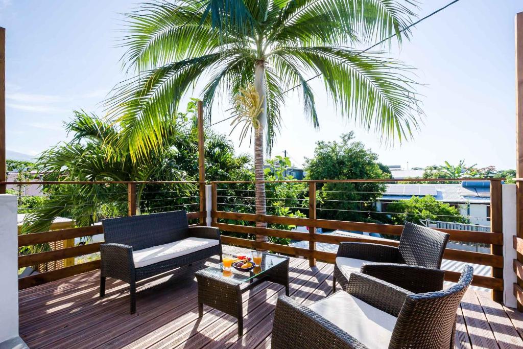 厄唐萨雷Kaz Combava的一个带椅子和桌子的庭院和棕榈树