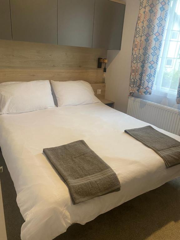 ChwilogHafan Y Môr Caravan - Pwllheli的一间卧室配有一张大床和两条毛巾