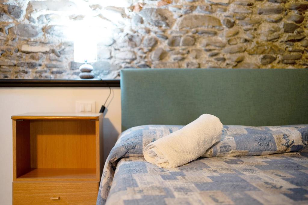 切尔沃Dipinti, borgo dei pescatori的一张带枕头的床铺,上面有石墙