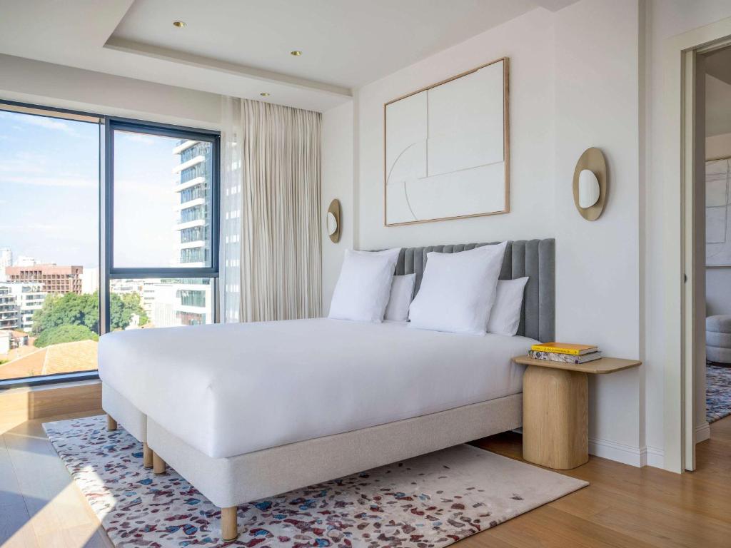 特拉维夫Elkonin Tel Aviv - MGallery Hotel Collection的卧室设有白色的床和大窗户