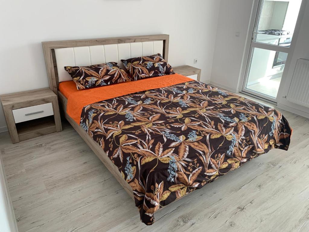 RoşuResidence Tineretului的一间卧室配有一张带橙色毯子的床