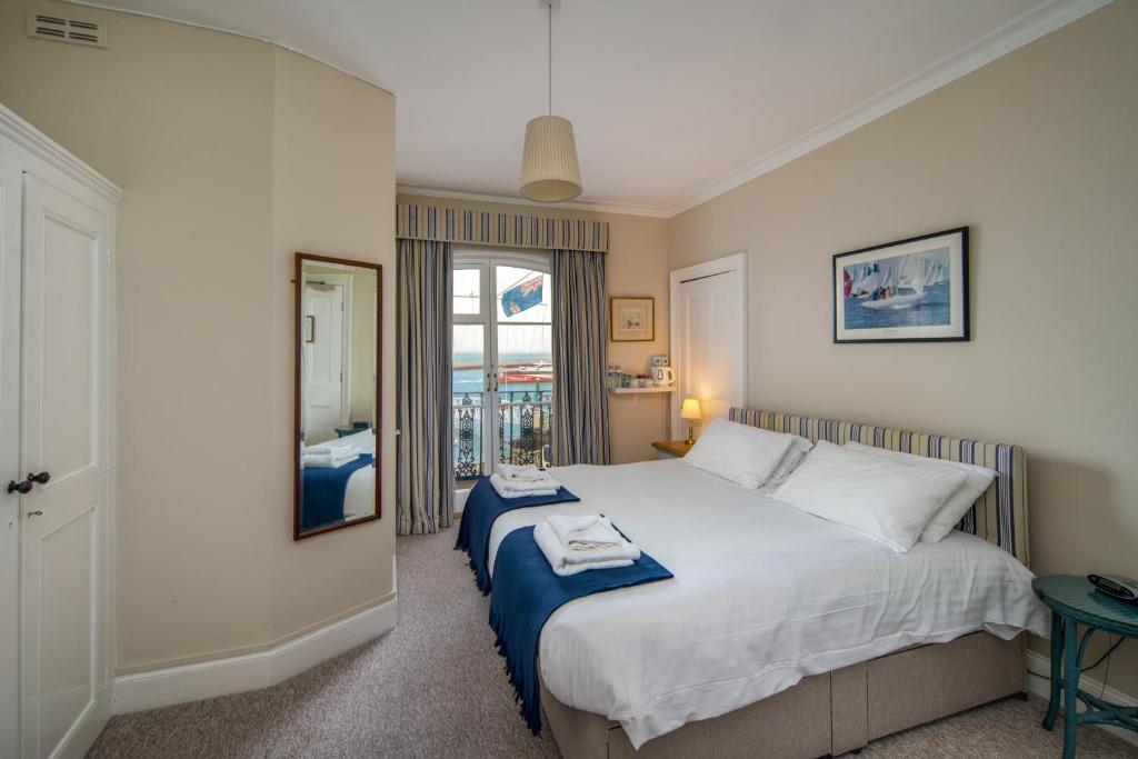 West CowesRoyal London Yacht Club的卧室设有一张白色大床和一扇窗户。