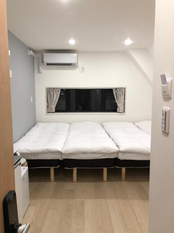 东京Oku Apartment的窗户前设有两张床的房间