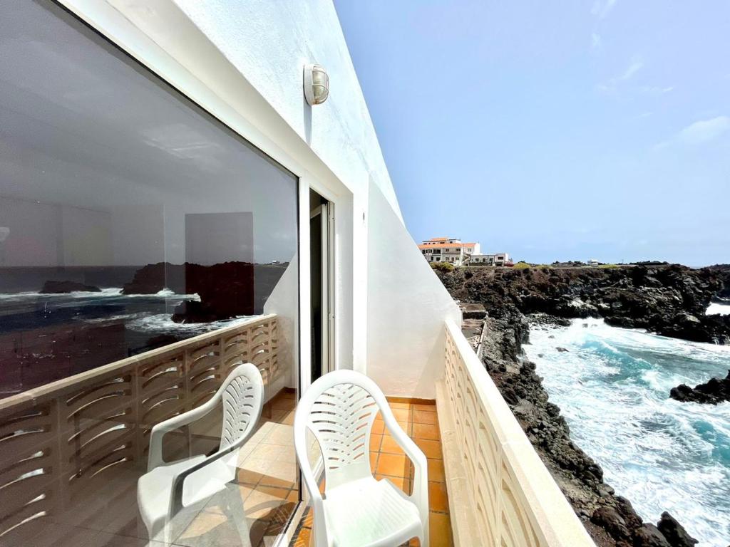 塔马达斯特Apartamento vista mar, a escasos metros de la playa的阳台配有两把椅子,享有海景。
