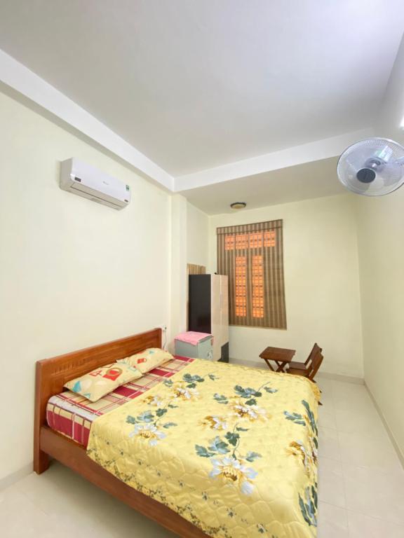岘港Win's Homestay的一间卧室配有一张黄色棉被的床
