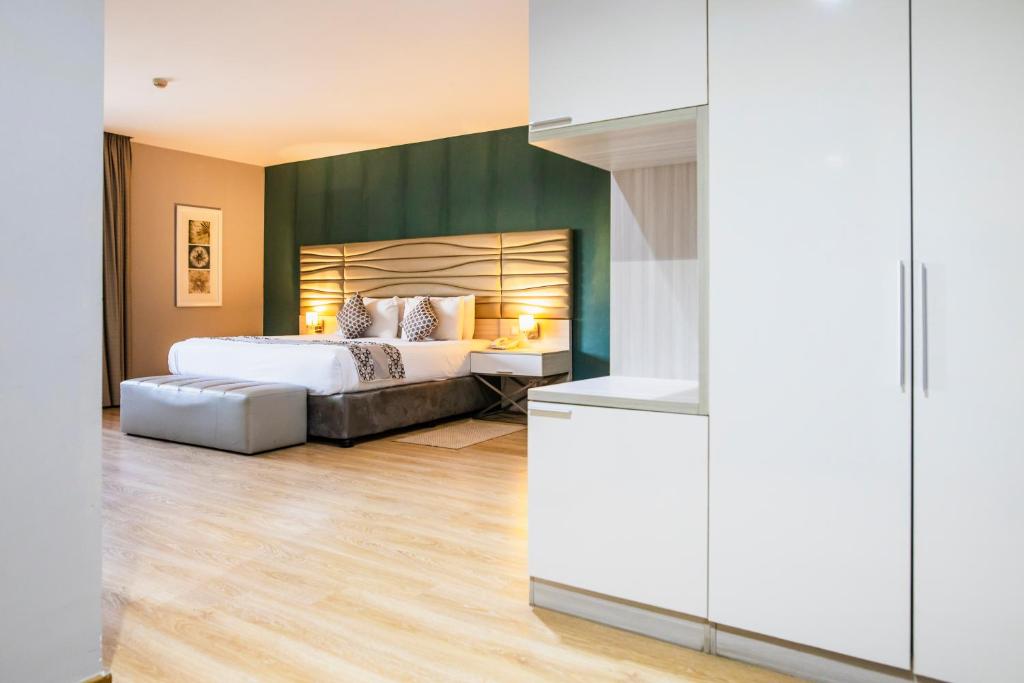 马普托马普托酒店的一间卧室设有一张床和绿色的墙壁