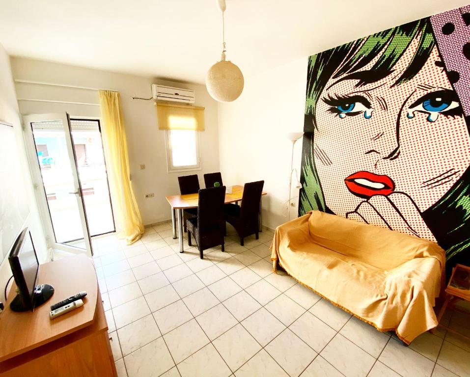 罗希姆诺Korona Beach Apartments I的客厅里有一幅大幅画画,画着一位女人