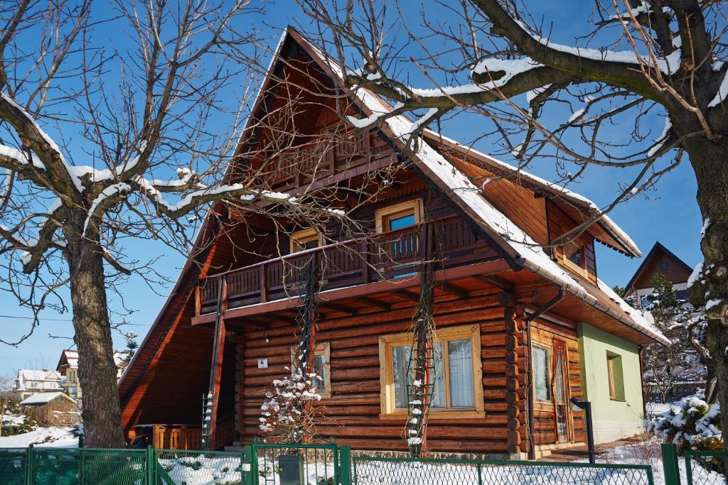 拉布卡Drewniany Dom Rabka Zdrój的小木屋,屋顶上积雪