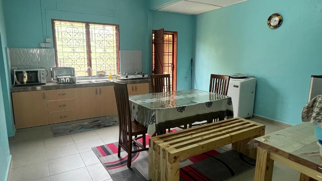 昔加末Segamat Tunas Homestay的厨房配有桌子和桌椅