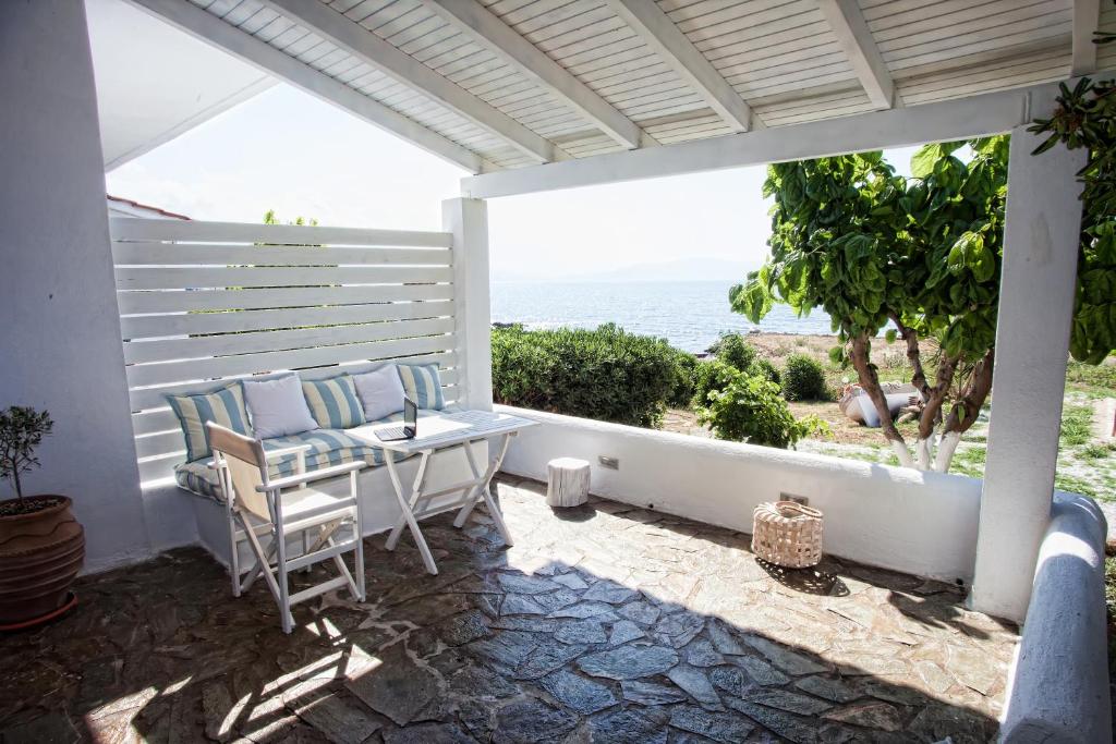 PetresArtemis Seafront Apartments的一个带桌椅的海景庭院