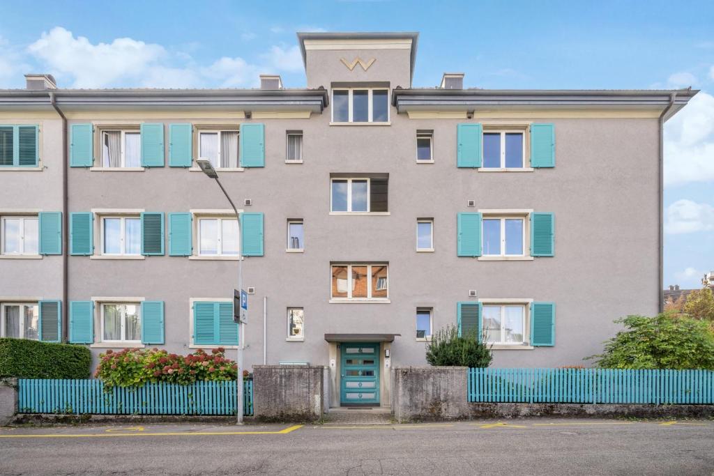 苏黎世Dohlenweg 2的公寓大楼设有蓝色百叶窗和蓝色围栏