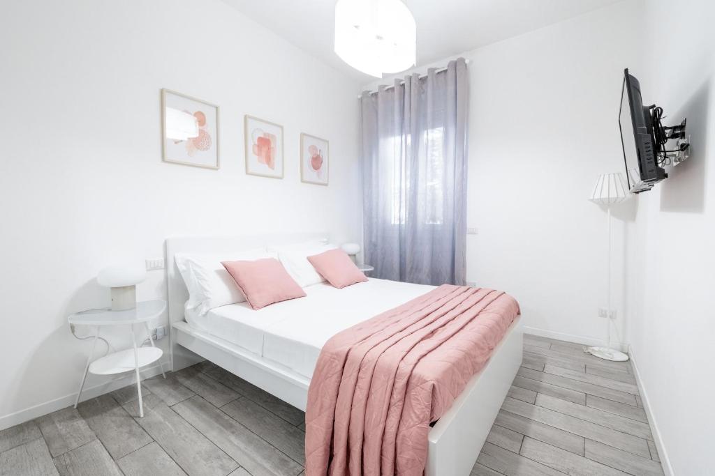 米兰拉福尔泰扎公寓的白色卧室配有一张带粉色毯子的床