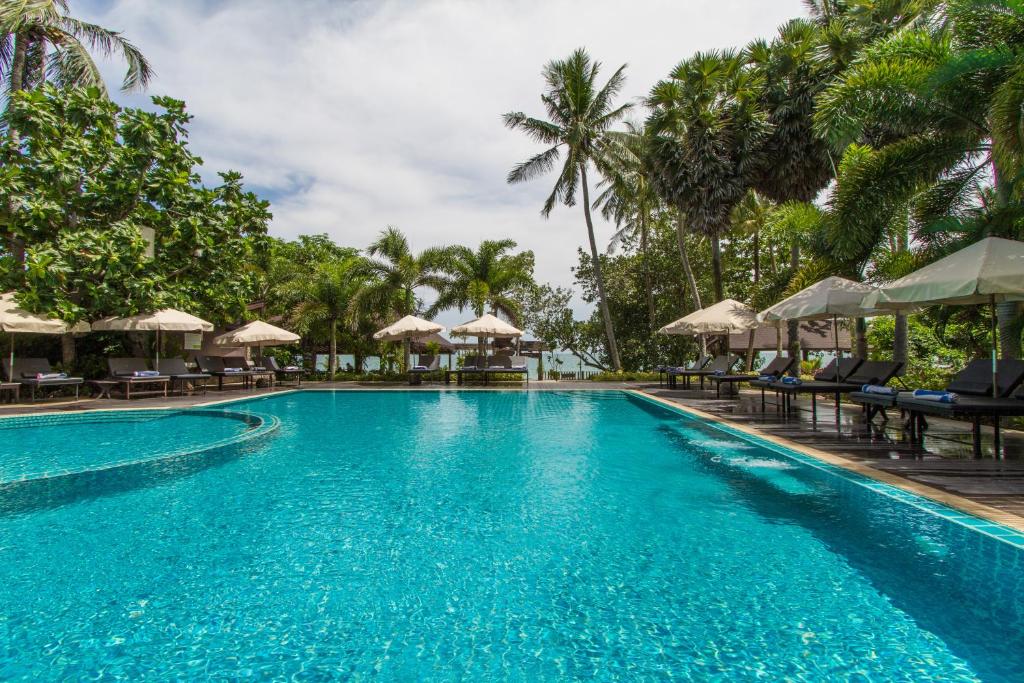 高兰安达兰达度假酒店的度假村的游泳池,配有椅子和遮阳伞