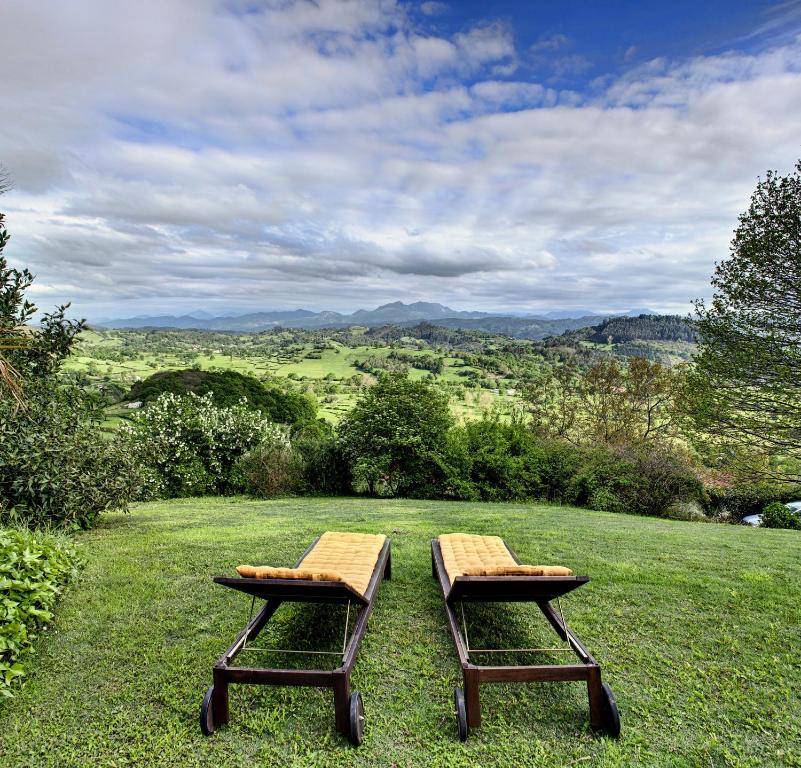 Careses埃尔米拉多尔奥迪亚乐斯乡村民宿的两个野餐桌坐在田野顶上