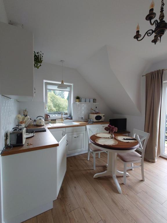 下乌斯奇基Noclegi Panorama的白色的厨房配有桌子和桌椅