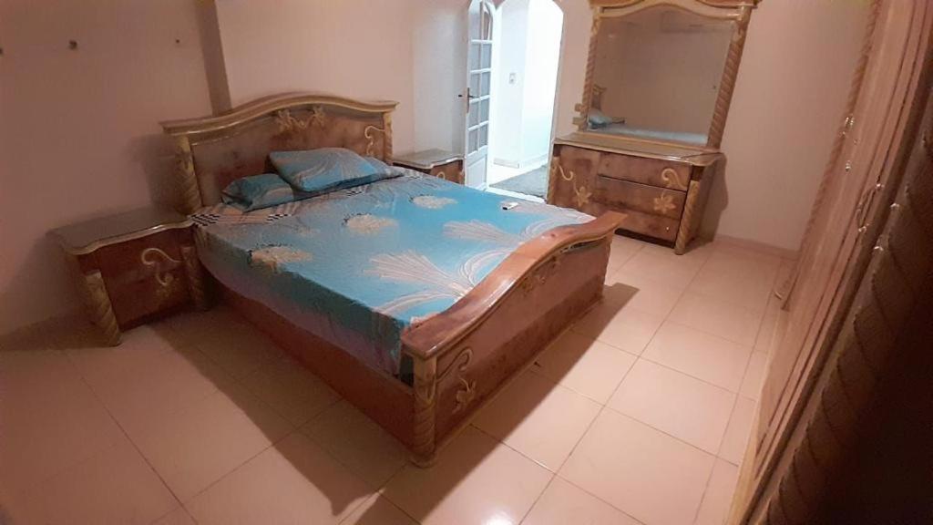 开罗شقة مفروشة للايجار فندقية جنينة مول الرئيسي的一间卧室配有一张大木床和镜子