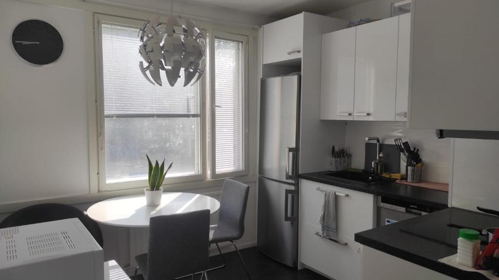 图尔库Central Park Home的白色的厨房,配有桌子和窗户
