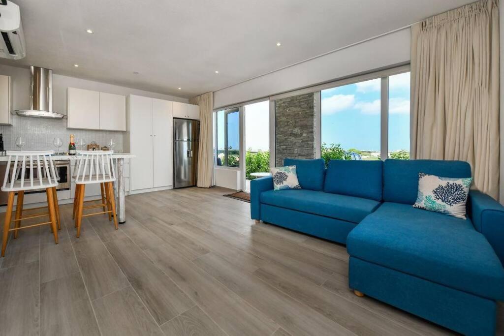 奥拉涅斯塔德Commandeurs Apartments unit 4D的一间带蓝色沙发的客厅和一间厨房
