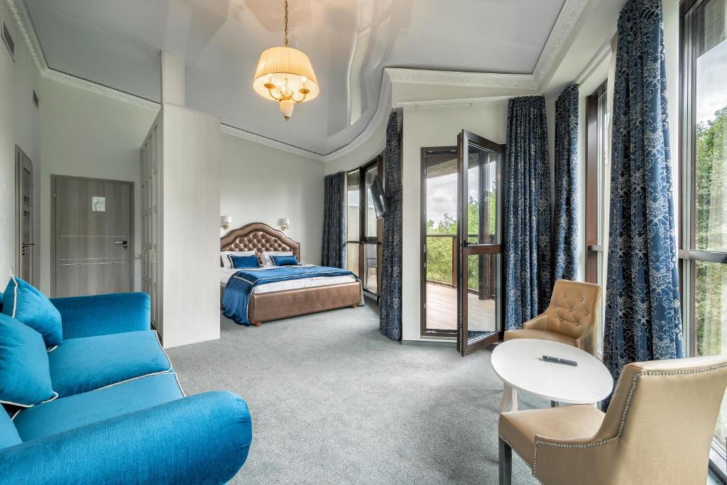 RadailiaiŽupė De Lux的酒店客房配有蓝色的沙发和床。
