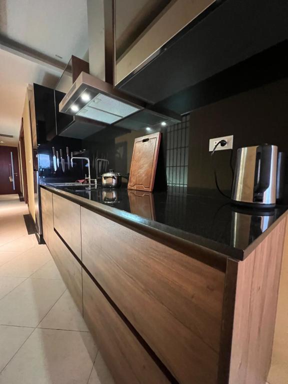卡塔海滩Luxury Apartment Kata Beach The Accenta的厨房配有黑色台面和木制橱柜