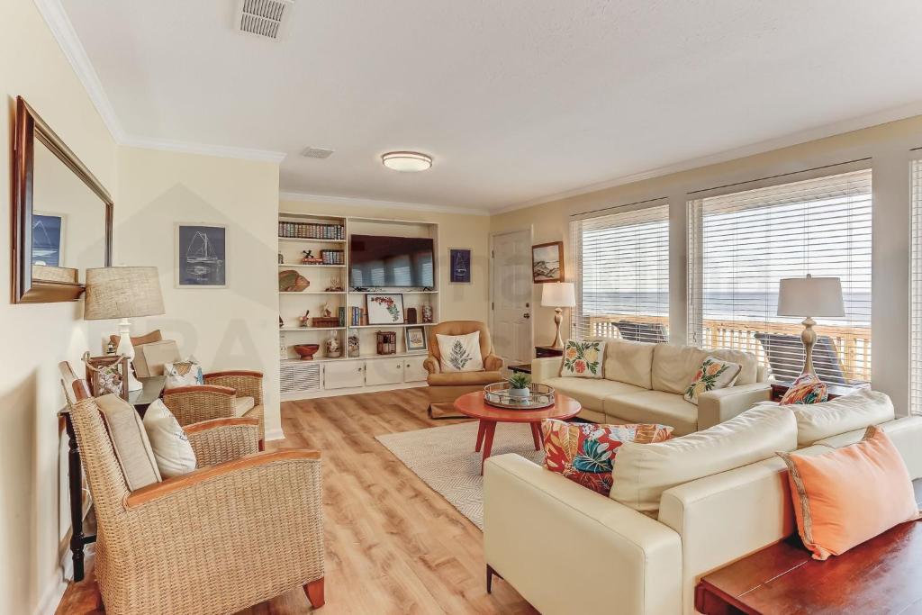 费南迪纳比奇Fletcher Beachfront Home的客厅配有沙发、椅子和桌子
