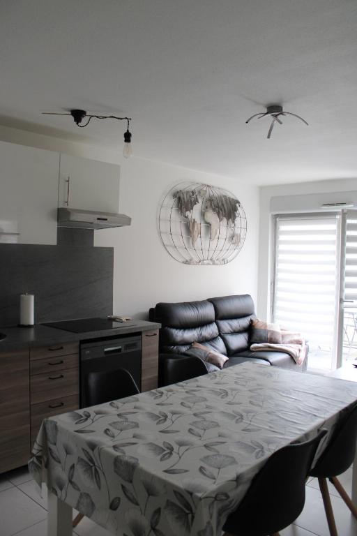 希尔蒂盖姆Appartement confortable avec parking privé的一间厨房,内设一张桌子和一张沙发