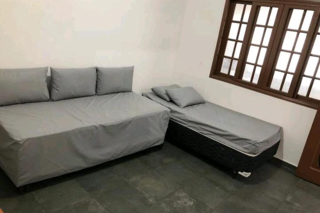 卡拉瓜塔图巴Cantinho do Sossego的两张床位于带窗户的房间内