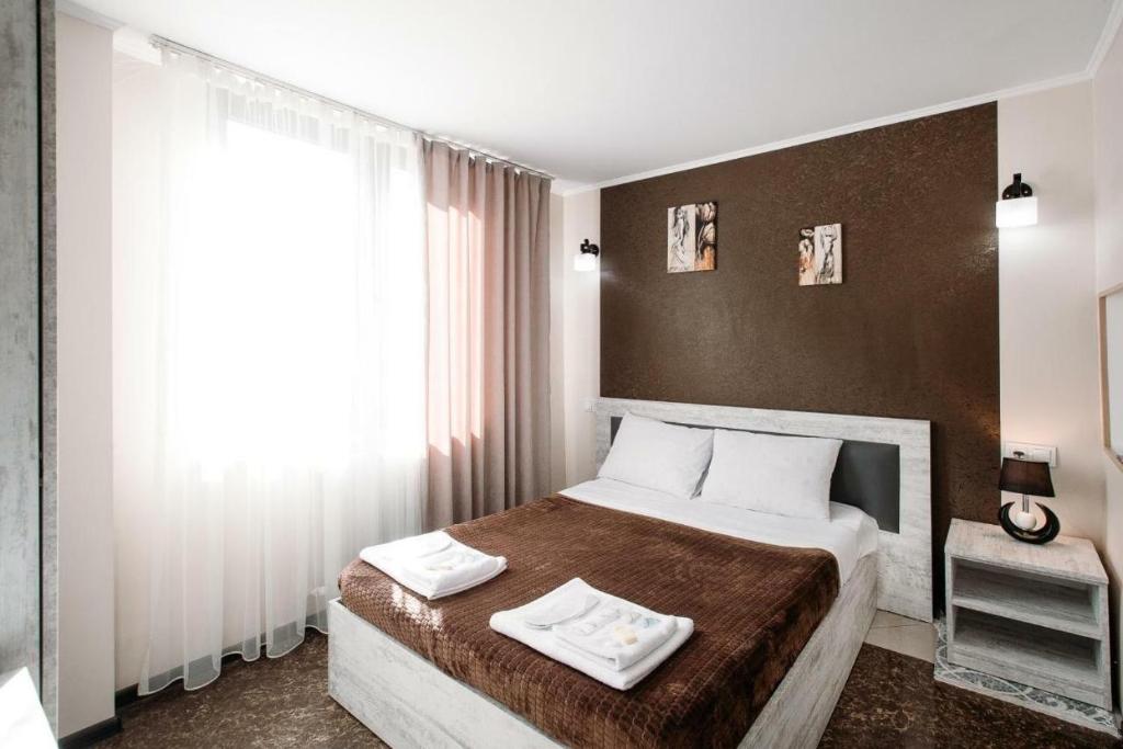 第比利斯HotelHarmony的一间卧室配有一张床,上面有两条毛巾