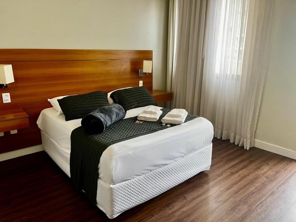 圣保罗Belíssimo FLAT - Faria Lima - Pinheiros的一间卧室配有一张床,上面有两条毛巾