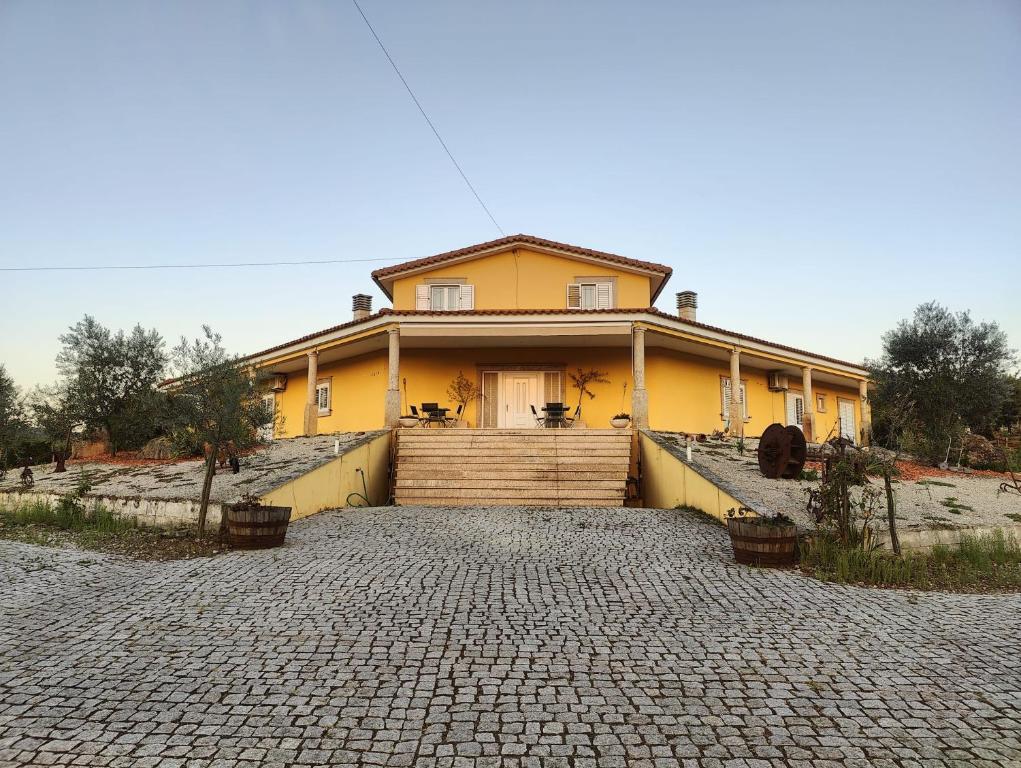米兰德拉Quinta da Libelinha Alojamento Local - Mirandela的前面有车道的黄色房子