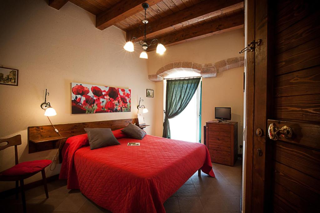科拉托Albergo Tripoli B&B Affittacamere的一间卧室设有红色的床和窗户。