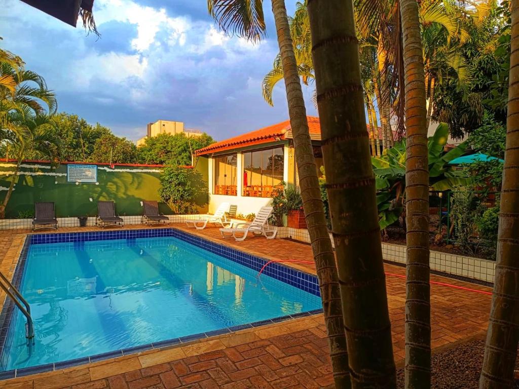 伊瓜苏POUSADA EVELINA的一座别墅前方的棕榈树游泳池
