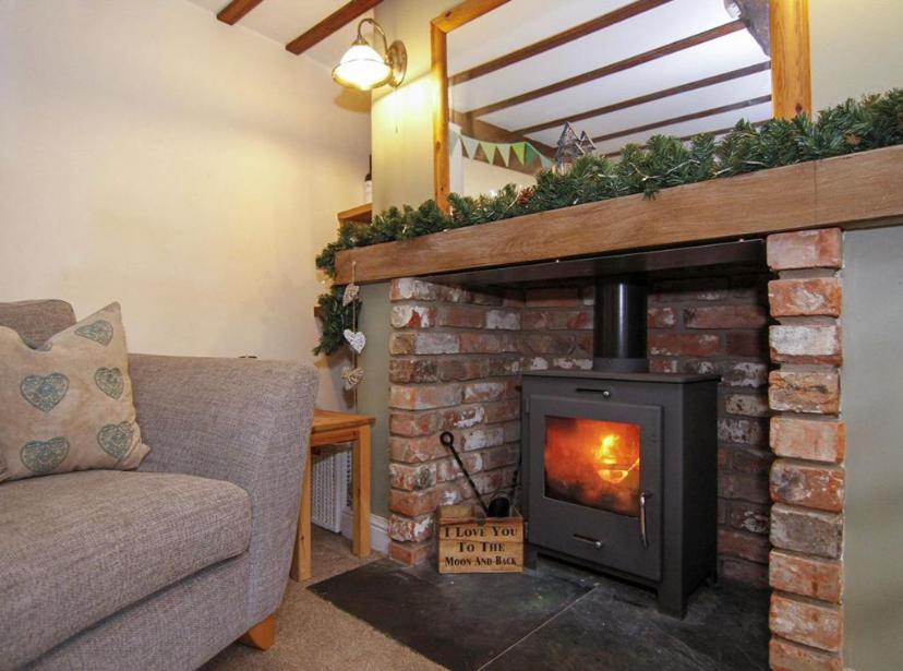 沃明斯特Daisy Cottage的客厅设有砖砌壁炉和炉灶