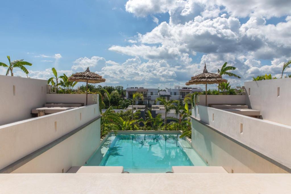 图卢姆Nãmas Tulum的设有一个游泳池的度假村阳台,享有风景