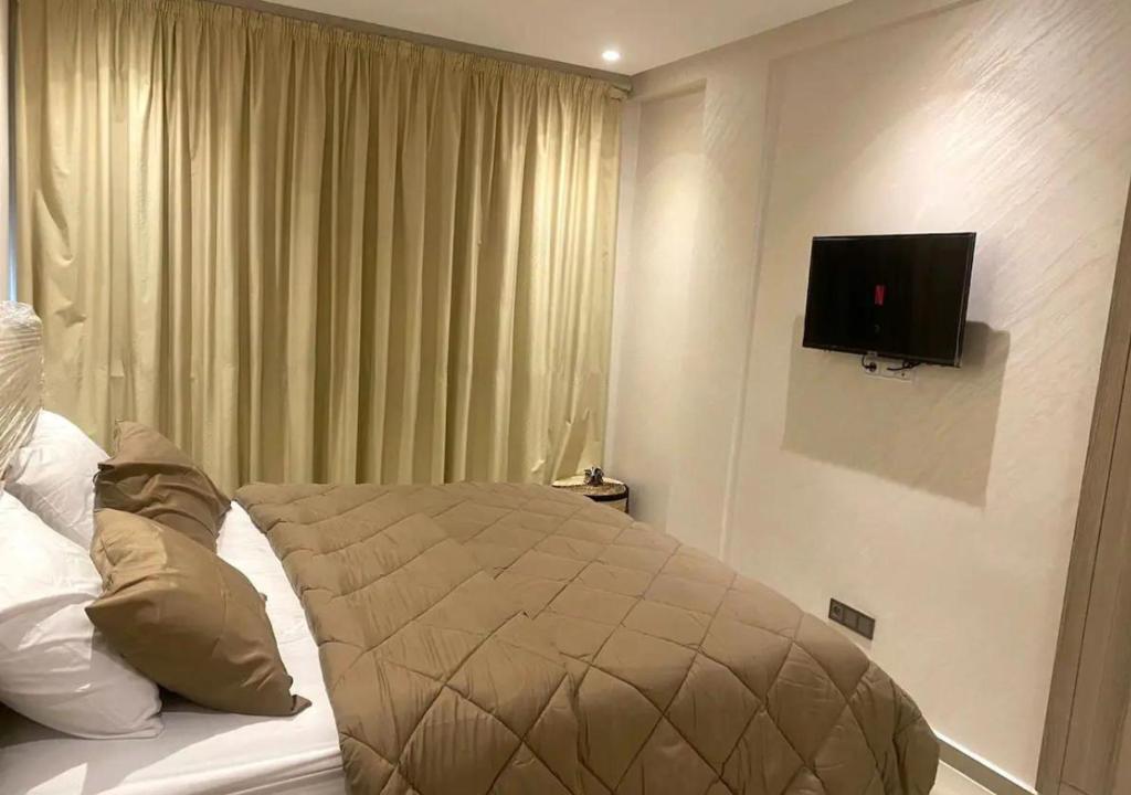 阿加迪尔CHIC & COSY appartement trés calme的卧室配有一张床铺,墙上配有电视