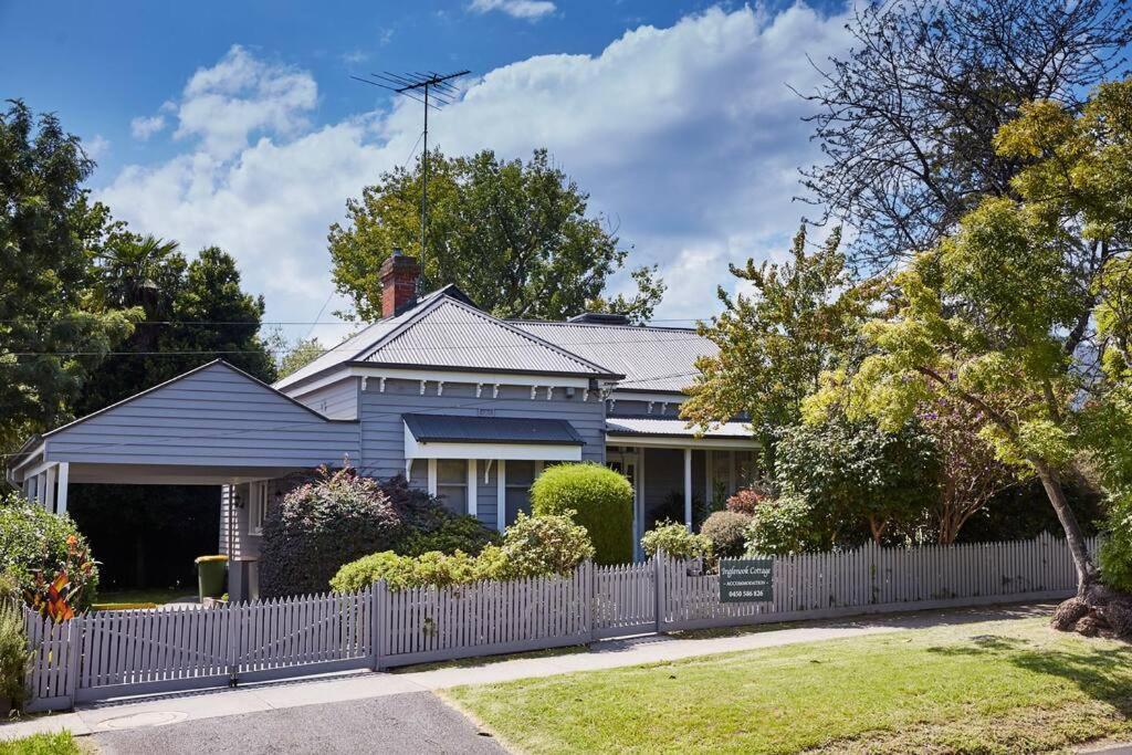 希尔斯维尔Inglenook Cottage Healesville的蓝色房屋,设有白色围栏