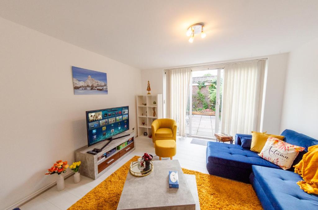 伦敦Spacious House near Kings Cross的客厅配有蓝色的沙发和电视