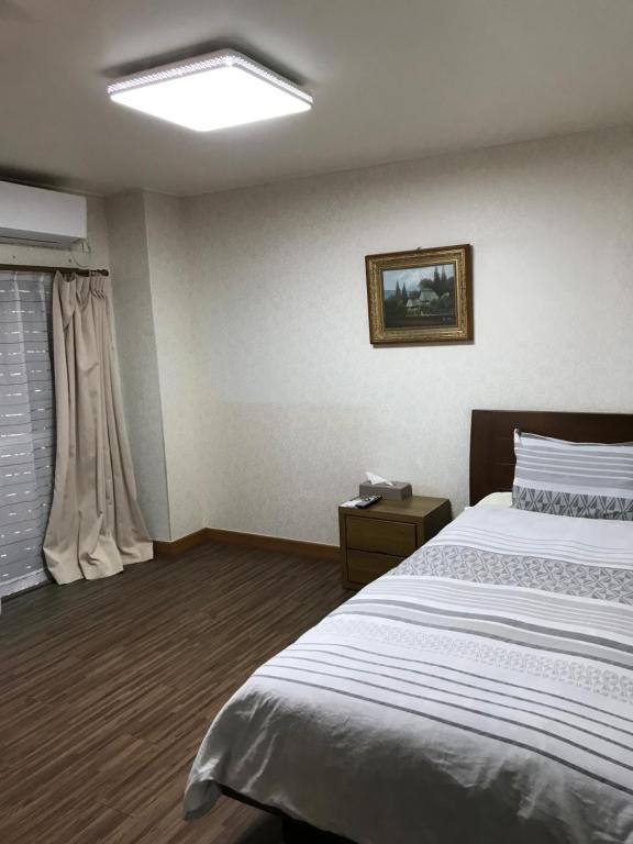 Katakaiゴールデンビーチホテル的一间卧室设有一张大床和一个窗户。