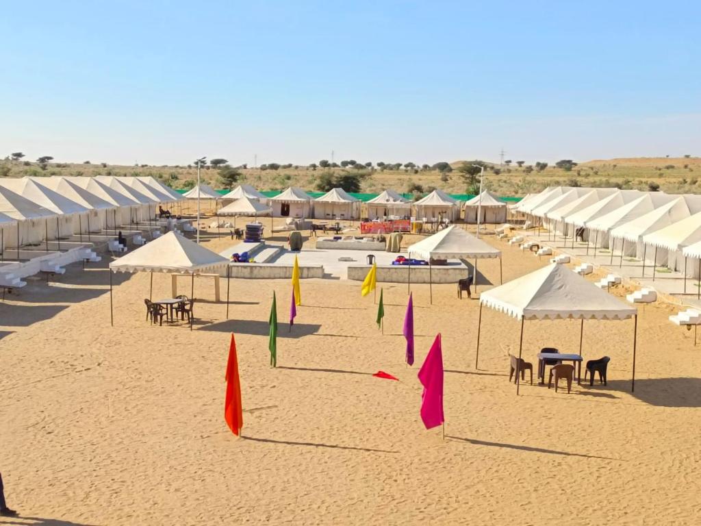 山姆Aroma Desert Safari Camp的海滩上配有白色遮阳伞和桌椅