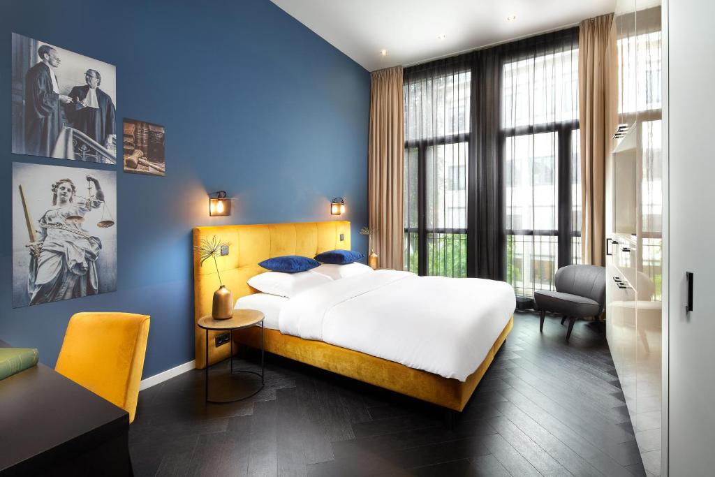 乌得勒支Court Hotel Utrecht City Centre的一间卧室设有一张大床和蓝色的墙壁
