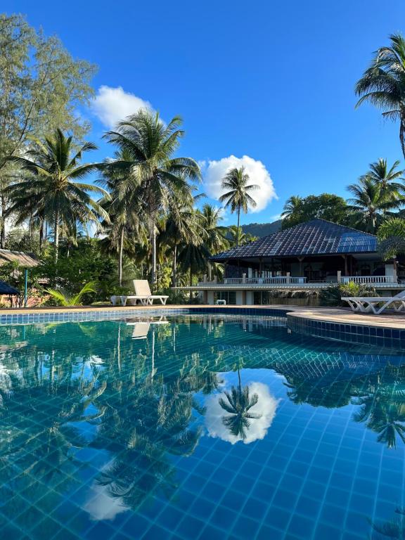 美翰Beachfront house in Chaloklum的一座棕榈树环绕的游泳池