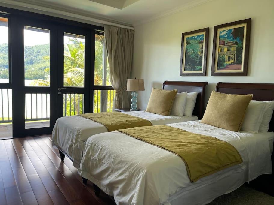 马埃岛Paradise Villa Eden Island的卧室设有两张床,带两个窗户