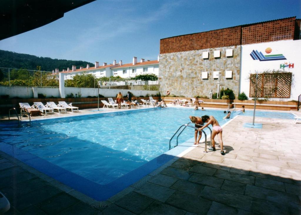 卡瓦尼亚斯萨尔加酒店的几个人站在游泳池里