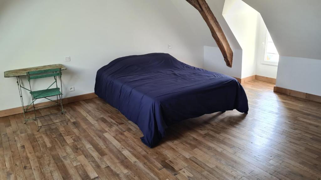 布尔格伊Maison Bourgueil的卧室铺有木地板,配有一张床和一张桌子。