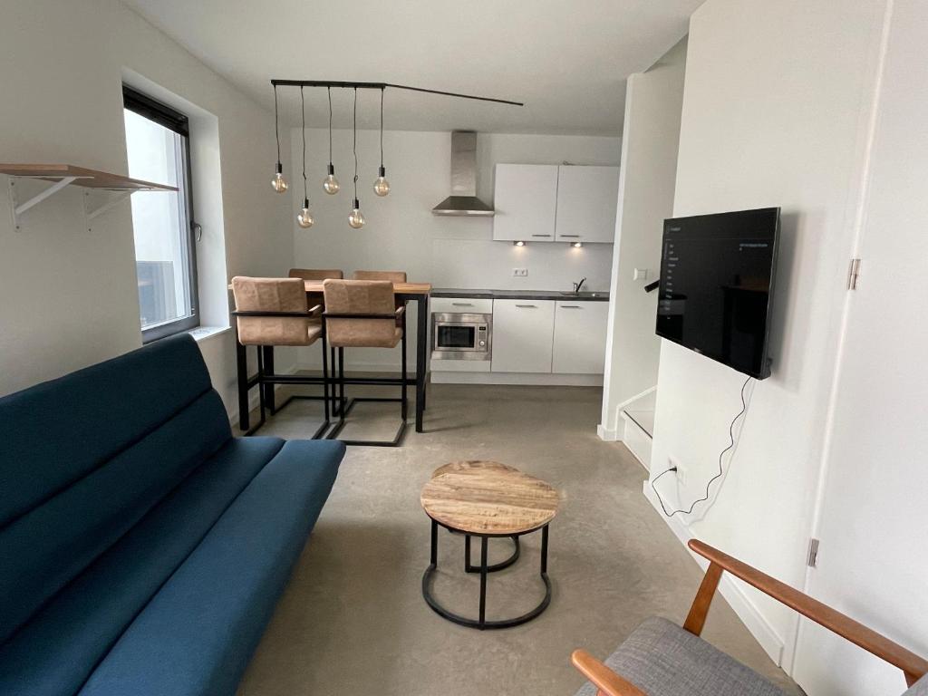 阿纳姆Home sweet home Arnhem的客厅配有蓝色的沙发和桌子